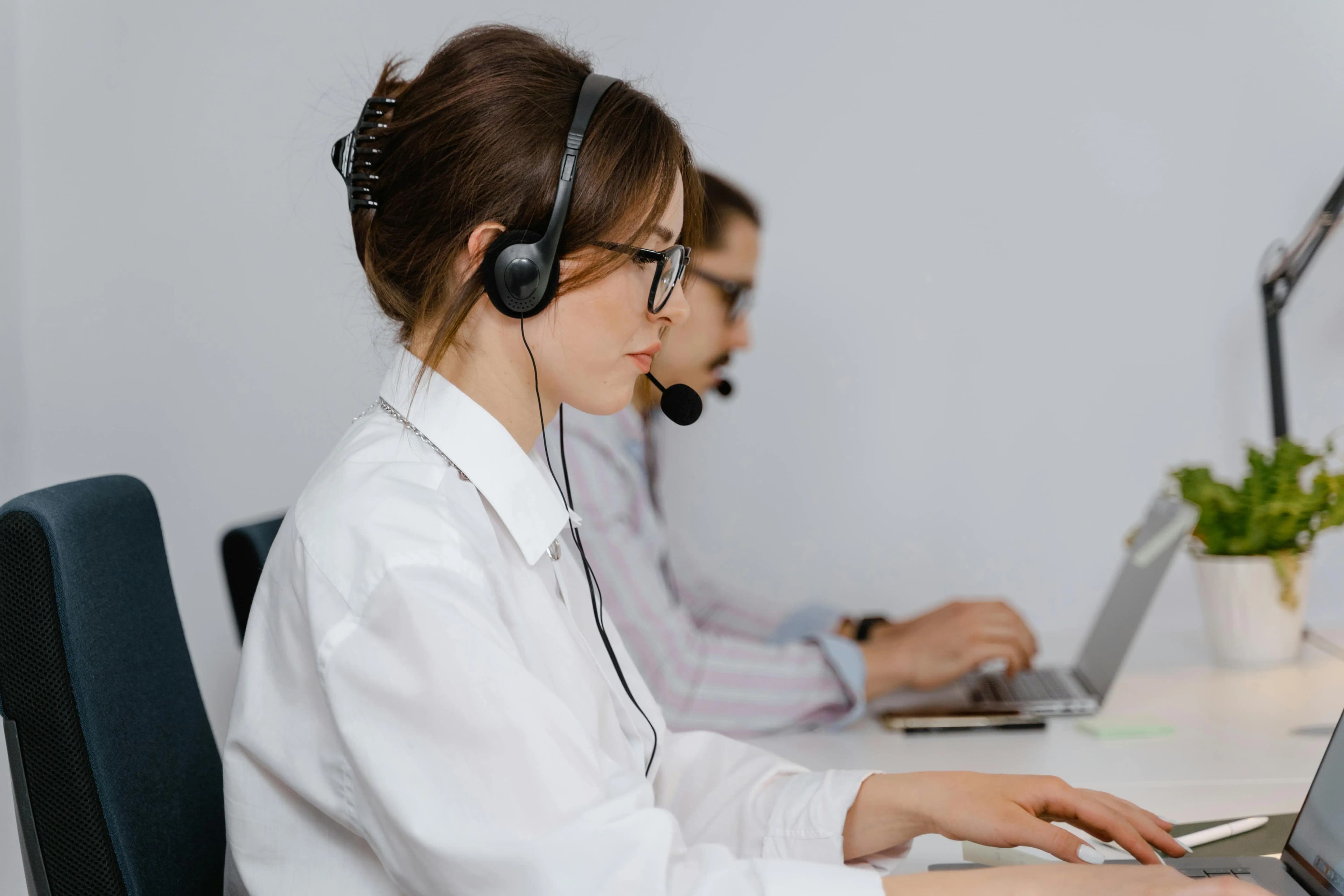 Worker at a support desk helping through a headset.