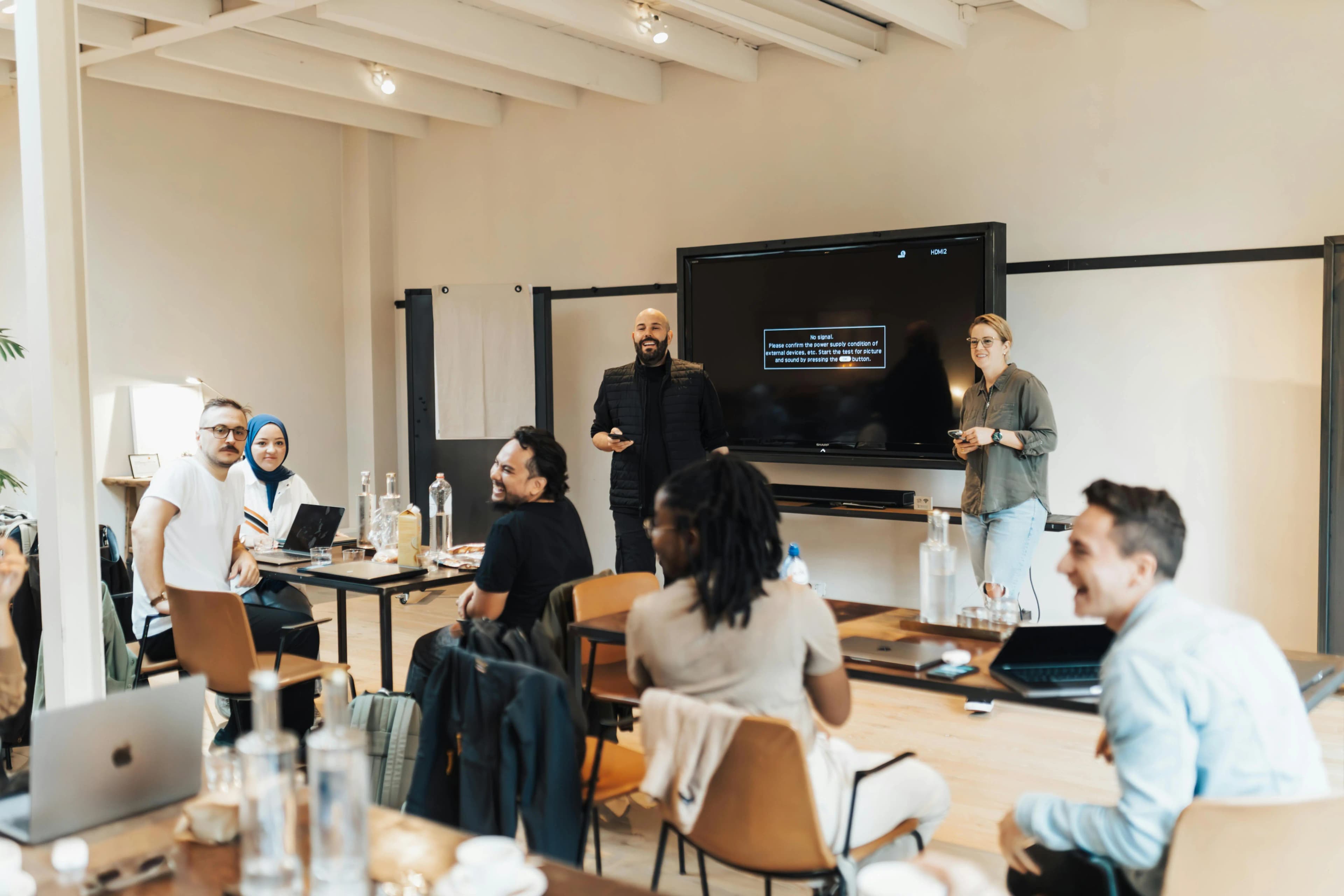 A class with two people presenting and attendees engaging in conversations.